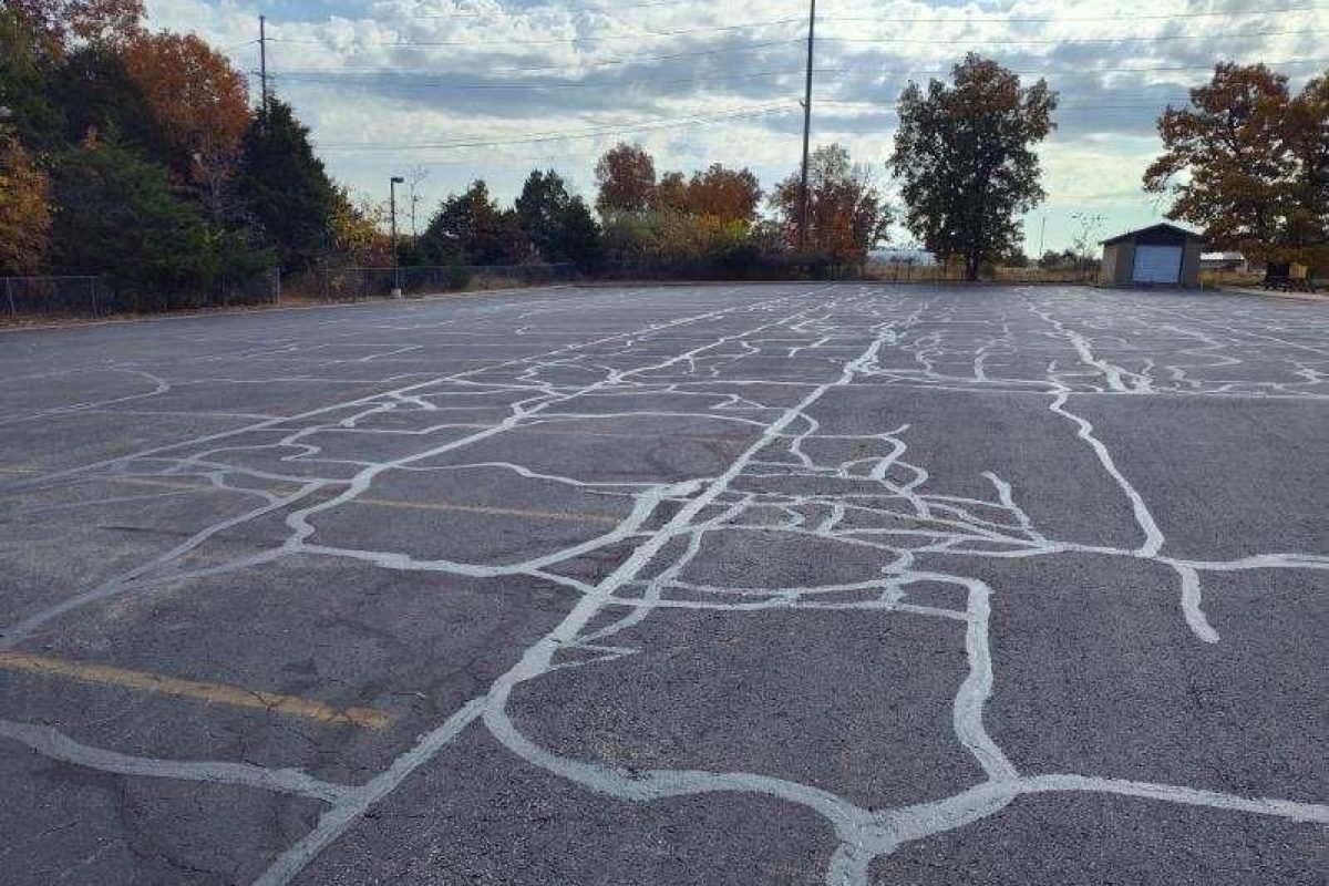 Before: Heavily cracked parking lot with faded markings
